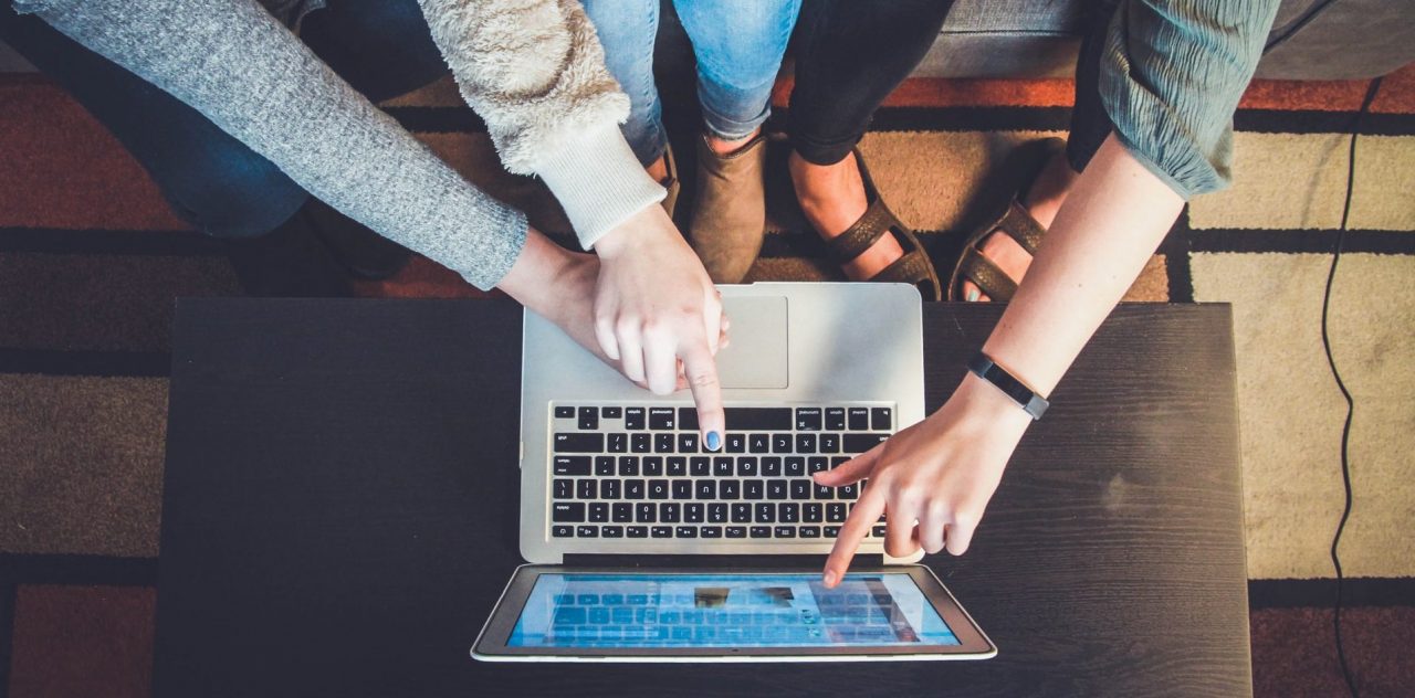 drei Hände am Laptop